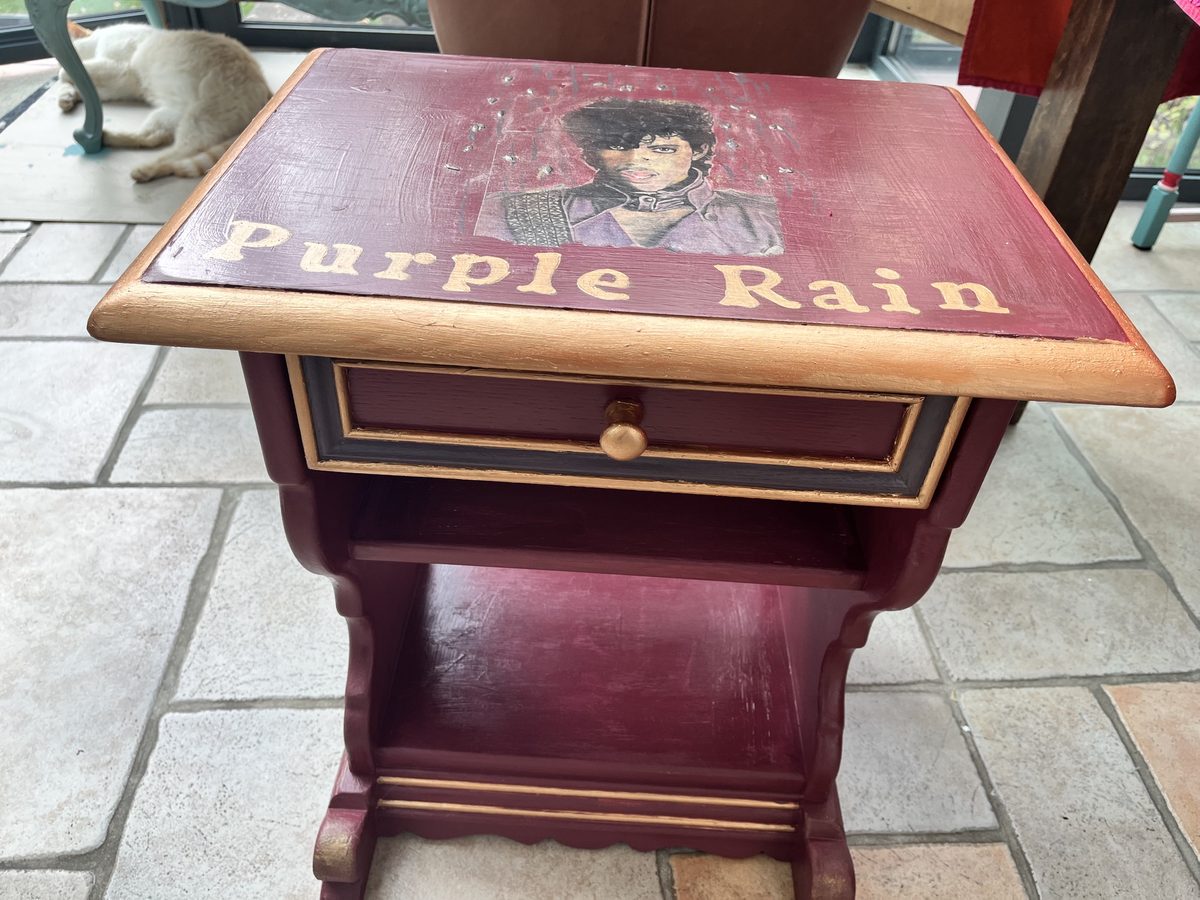 Purple Rain im Wintergarten – handgemaltes Porträt und Schriftzug auf der Tischplatte